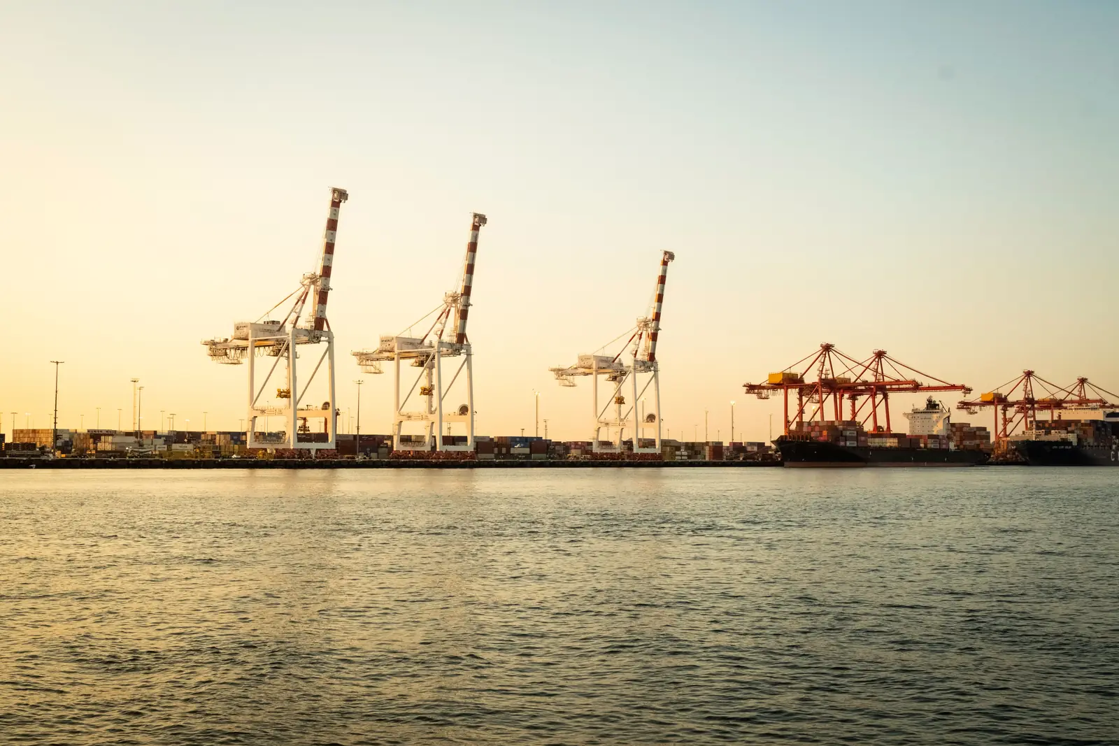 Container cranes and ships at Fremantle Port at sunset