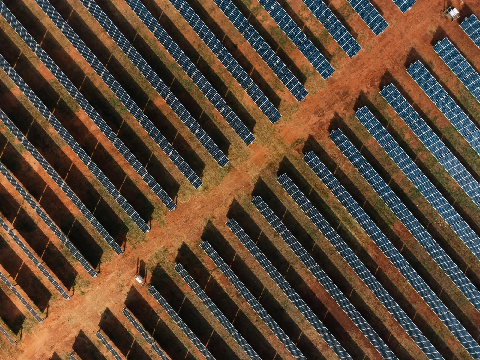 Rows of solar panels on red earth in the Northern Territory, from the air